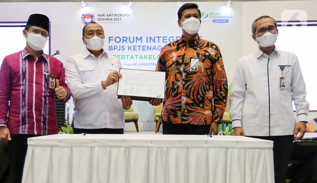 Anggota DJSN Subiyanto, Ketua Dewan Pengawas BPJAMSOSTEK Muhammad Zuhri, Direktur Utama BPJAMSOSTEK Anggoro Eko Cahyo dan Pimpinan KPK RI Alexander Marwata usai menandatangani Sistem Manajemen Anti Penyuapan (SMAP) di Plaza BPJAMSOSTEK, Jakarta (13/12/2021). (Liputan6.com/Fery Pradolo)