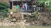 Warga beraktivitas di bantaran Sungai Ciliwung, Kampung Tanah Rendah, Jakarta, Jumat (15/11/2019). Pemprov DKI Jakarta membatalkan pembebasan 118 bidang tanah di bantaran Sungai Ciliwung yang disebabkan karena defisit anggaran. (Liputan6.com/Herman Zakharia)