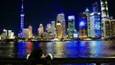 Seorang anak menonton pertunjukan cahaya di The Bund, Shanghai, China timur (4/11/2020). Sebuah pertunjukan cahaya bertema gelaran Pameran Impor Internasional China (China International Import Expo/CIIE) digelar di Lujiazui pada Rabu (4/11). (Xinhua/Zhang Haofu)