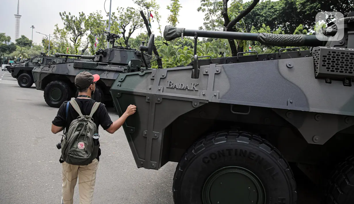 Warga memegang kendaraan alat utama sistem senjata (alutsista) TNI yang berjajar di kawasan Istana Merdeka, Jakarta, Selasa (4/10/2022). Kegiatan ini dalam rangka HUT ke-77 TNI yang akan berlangsung di Istana Merdeka pada 5 Oktober besok. (Liputan6.com/Faizal Fanani)