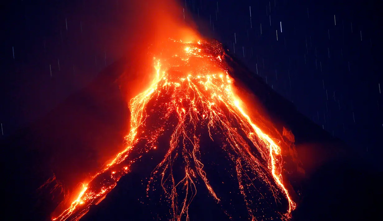 Pemandangan ketika lava panas keluar dari puncak Gunung Mayon yang berada di Kota Legazpi, Provinsi Albay, Filipina, Selasa (23/1). Gunung berapi paling aktif di Filipina ini mengeluarkan lava, abu, dan asap. (AP Photo/Bullit Marquez)