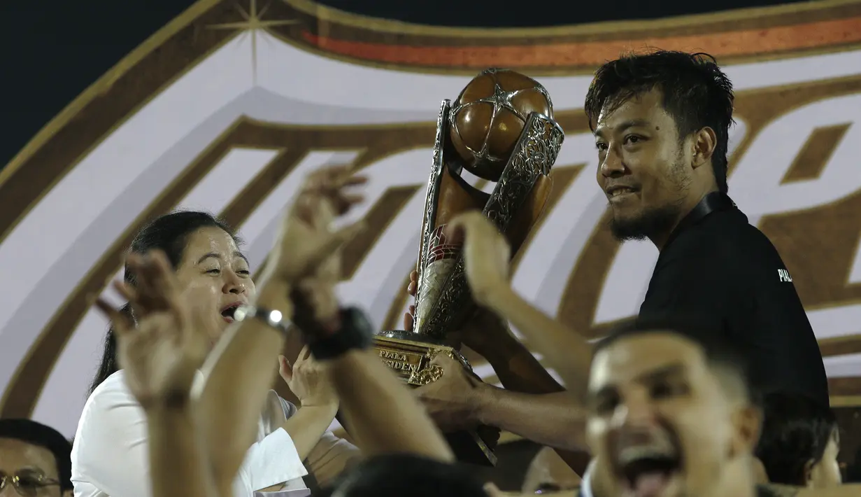 Kapten Arema FC, Hamkah Hamzah, merayakan gelar juara Piala Presiden 2019 usai menaklukkan Persebaya Surabaya di Stadion Kanjuruhan, Jumat (13/4). Arema FC menang 2-0 atas Persebaya. (Bola.com/Yoppy Renato)