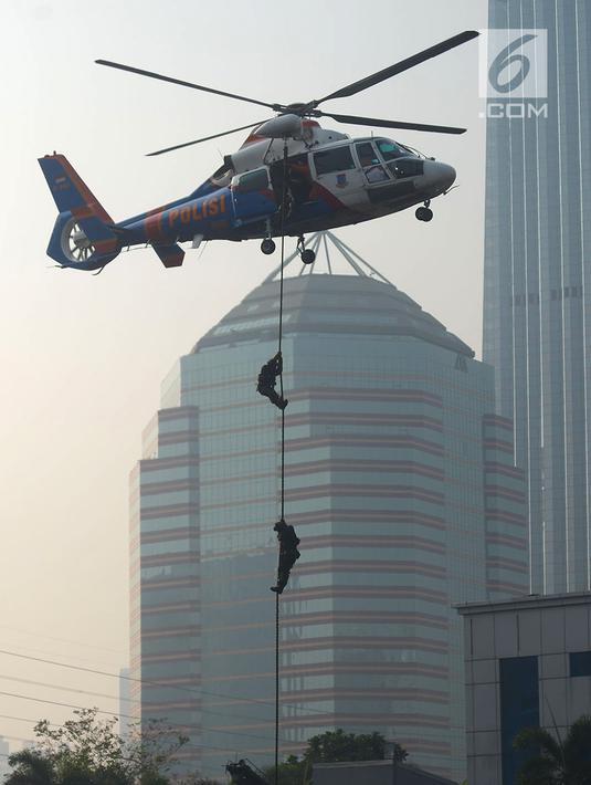 Petugas kepolisian menuruni helikopter menggunakan tali dalam apel pengamanan Asian Games 2018 di Lapangan Ditlantas Polda Metro Jaya, Jakarta, Selasa (31/7). (Merdeka.com/Imam Buhori)