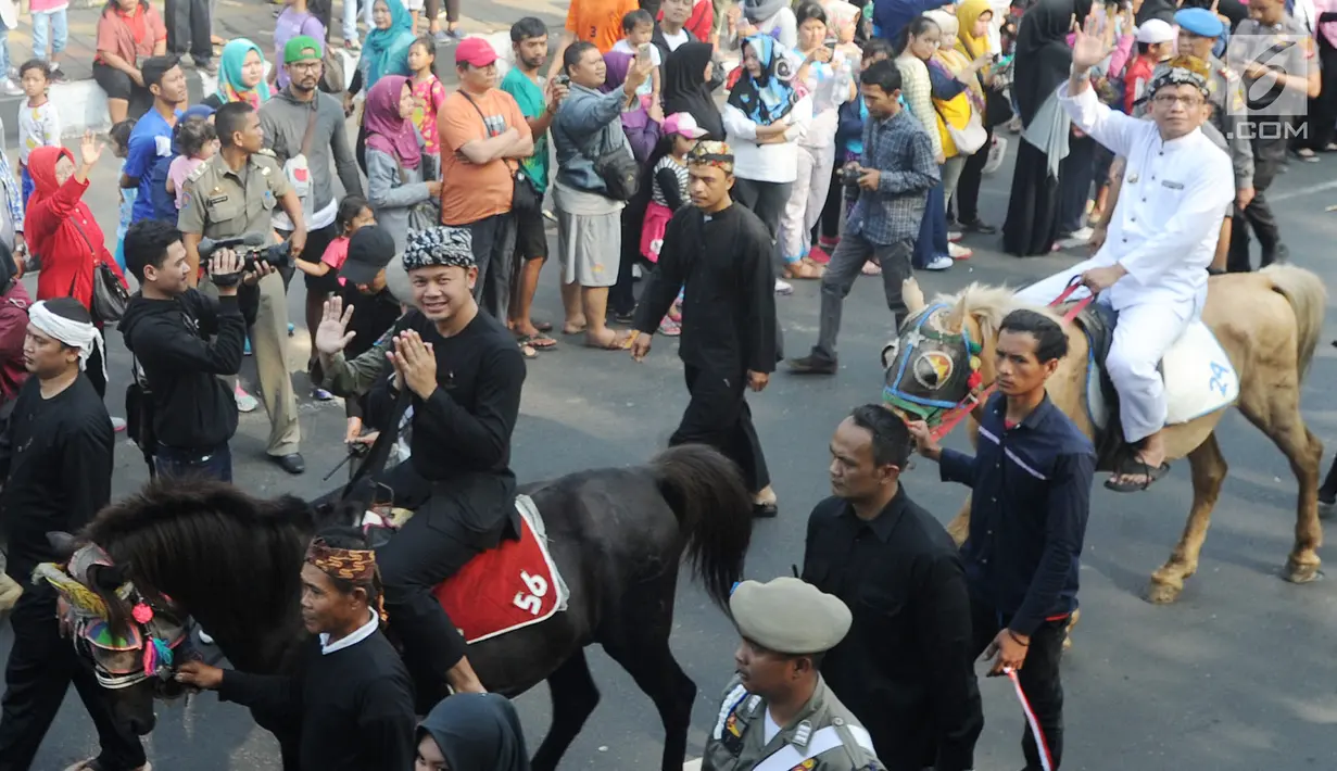 Wali Kota Bogor Bima Arya (depan) bersama Wakil Wali Kota Bogor Usmar Hariman (belakang) naik kuda saat ikut festival budaya Helaran 2018, Bogor, Jawa Barat, Minggu (12/8). Helaran merupakan acara puncak HUT ke-536 Bogor. (Merdeka.com/Arie Basuki)