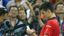 Petenis  Novak Djokovic melakukan tanda tangan di kamera usai menang atas petenis Italia Simone Bolelli di China Open tennis tournament, Beijing, China, Selasa (06/10/2015).  (REUTERS/Kim Kyung-Hoon)