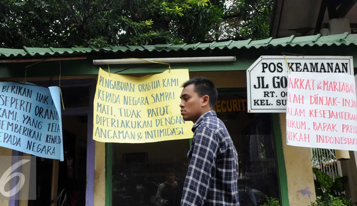 Warga melintas di depan rumah negara yang akan dikosongkan saat mengelar aksi di kawasan sungai bambu, Jakarta Utara, Rabu (3/2). Dalam aksi mereka menolak pengosongan rumah negara secara paksa terhadap 6 rumah negara. (Liputan6.com/Helmi Afandi)