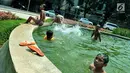 Sejumlah anak mandi bermain di bundaran air mancur Jalan Teuku Umar, Jakarta Pusat, Sabtu (23/9). Cuaca panas ibu kota memaksa anak-anak menceburkan diri di kolam untuk menyejukkan badan. (Liputan6.com/Helmi Afandi)