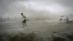 Seorang pria berusaha berlari saat gelombang ombak besar menerjang Wanning akibat Topan Sarika di provinsi Hainan, Tiongkok, (18/10). (REUTERS/Stringer)