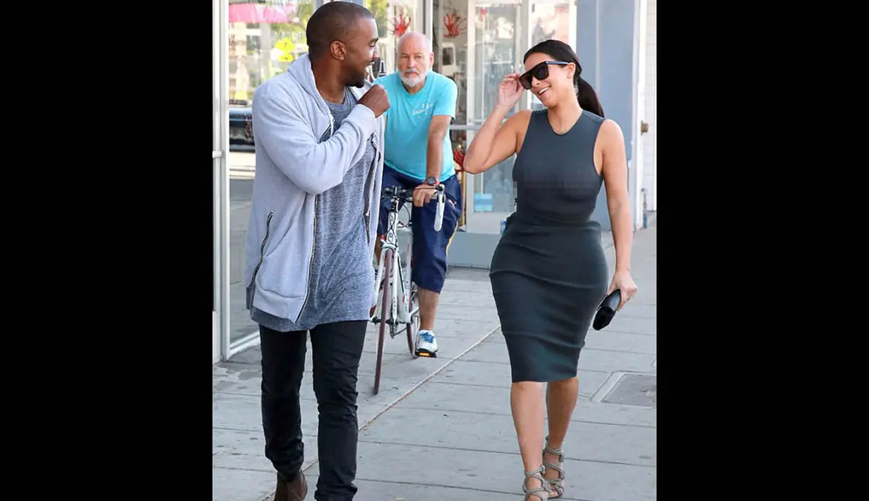Suami Kim, Kanye West terlihat tertawa meski mengetahui ada fotographer yang mengambil gambar mereka di sekitar kawasan Hollywood, Amerika, (12/10/14). (Dailymail)