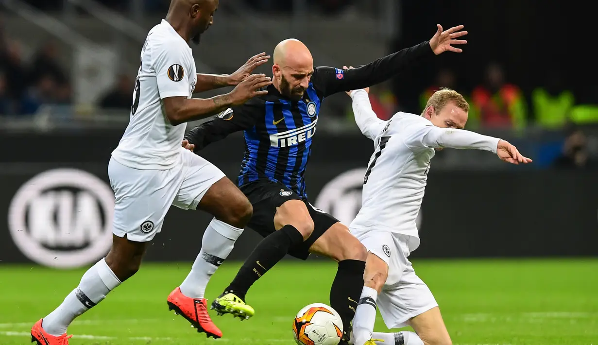 Borja Valero mencoba melewati dua pemain Eintracht Franckfurt pada leg kedua, babak 16 besar Liga Europa yang berlangsung di Stadion Giuseppe Meazza, Jumat (15/3). Inter Milan kalah 0-1 kontra Eintracht Frankfurt. (AFP/Miguel Medina)