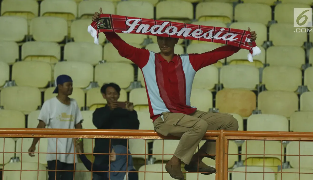Suporter membentangkan syal bertuliskan Indonesia usai menyaksikan laga Timnas Indonesia U-16 melawan Singapura U-16 di Stadion Wibawa Mukti, Kab Bekasi, Kamis (8/6). Indonesia U-16 menang telak 4-0. (Liputan6.com/Helmi Fithriansyah)