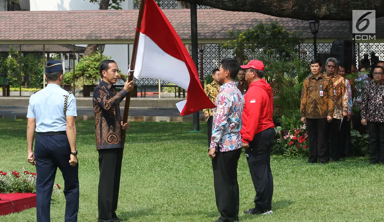 Presiden Joko Widodo memberikan bendera merah putih kepada Ketum INAPGOC 2018 Raja Sapta Oktohari saat pelepasan kontingen atlet dan official Indonesia Asian Para Games 2018 di Halaman Istana Negara, Jakarta, Selasa (2/10). (Liputan6.com/Angga Yuniar)