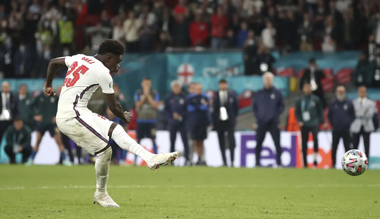 Pemain Inggris Bukayo Saka menendang penalti ke gawang Italia pada pertandingan final Euro 2020 di Stadion Wembley, London, Inggris, Minggu (11/7/2021). Italia menang 3-2 lewat adu penalti usai bermain imbang 1-1 di waktu normal. (Nick Potts/PA via AP)