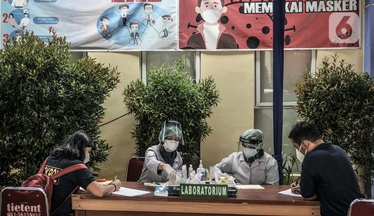 Tenaga kesehatan mendata keluarga korban Sriwijaya Air SJ 182 yang akan tes usap COVID-19 sebelum memberikan data di Posko Ante Mortem DVI, RS Polri, Jakarta, Minggu (10/1/2020). Keluarga korban mulai berdatangan ke posko ante mortem pascajatuhnya Sriwijaya Air SJ 182. (merdeka.com/Iqbal S. Nugroho)