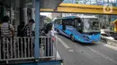 Sejumlah calon penumpang menunggu kedatangan bus Transjakarta di Halte Harmoni, Jakarta, Senin (10/1/2022). PT Transportasi Jakarta (Transjakarta) melakukan penyesuaian jam operasional usai ditetapkannya status PPKM menjadi Level 2 di Jakarta. (Liputan6.com/Faizal Fanani)