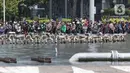 Warga berkumpul untuk menyaksikan parade pembalap MotoGP di kawasan Jakarta, Rabu (16/3/2022).  Gelaran parade MotoGP di Jakarta dalam rangka penyambutan event MotoGP Mandalika 2022. (Liputan6.com/Herman Zakharia)