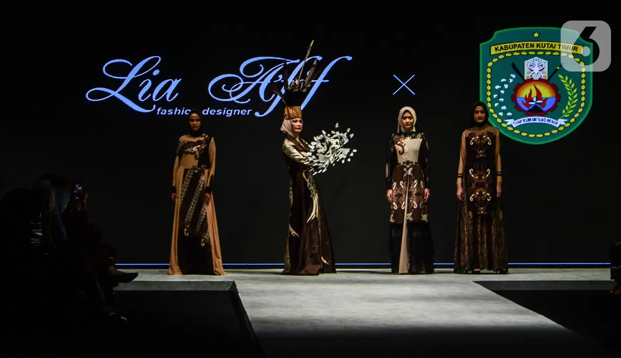 Model mengenakan busana kain rancangan karya LIA AFIF fashion desainer berkolaborasi dengan Pemkab Kutai Timur pada Indonesia Fashion Week 2022 di Jakarta Convention Center, Rabu (13/4/2022). Perhelatan Indonesia Fashion Week kembali digelar setelah dua tahun absen. (Liputan6.com/JohanTallo)