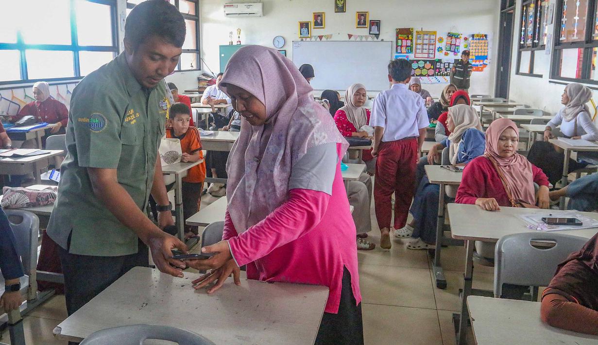 Program tersebut memberikan kemudahan bagi siswa dan orang tua dalam mengurus dokumen kependudukan secara langsung di lingkungan sekolah tanpa harus datang ke kantor pelayanan. Tampak dalam foto, salah satu orang tua murid saat mengikuti pelaksanaan program Layanan Anak Sekolah Suku Dinas Kependudukan dan Pencatatan Sipil (Dukcapil) Jakarta Selatan (Laksana Sultan) di Sekolah Dasar Negeri (SDN) Kebagusan 01, Pasar Minggu, Jakarta, Senin (4/5/2026). (merdeka.com/Arie Basuki)