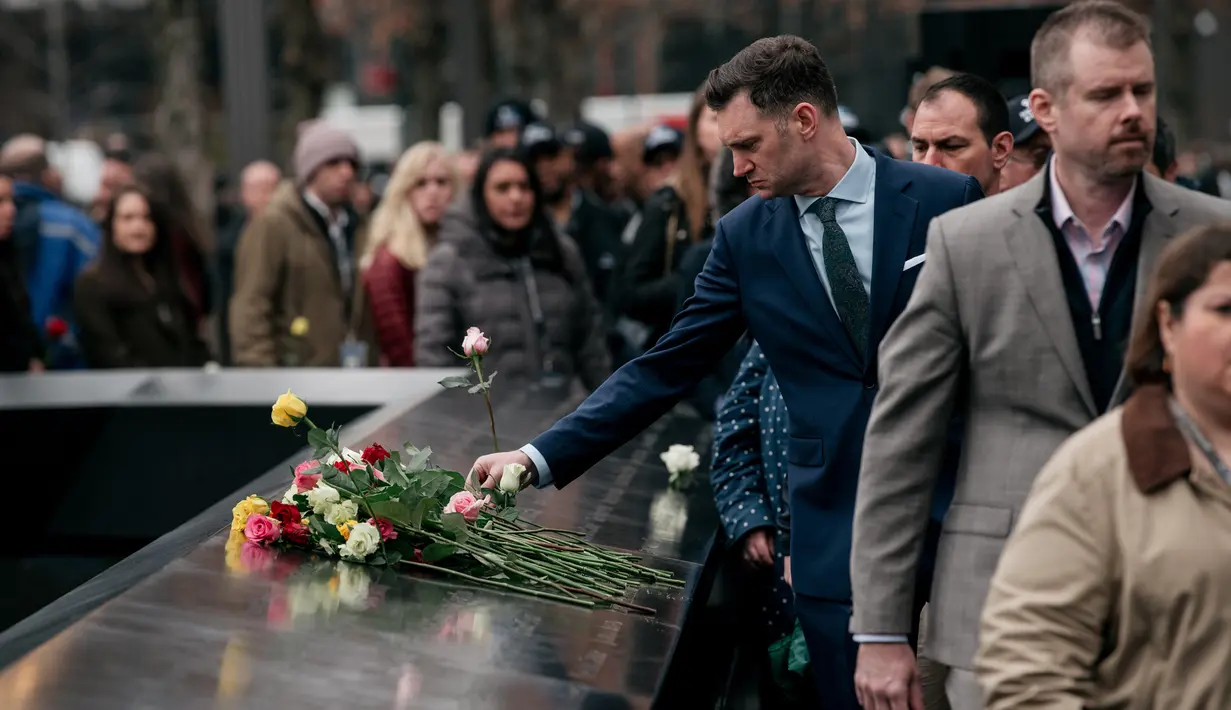 Kerabat dan pelayat meletakkan mawar di atas plakat bertuliskan nama-nama korban pengeboman World Trade Center 1993 pada upacara peringatan di New York, Rabu (26/2/2020). 27 tahun lalu teroris meledakkan bom di sebuah garasi parkir WTC yang menewaskan enam korban. (Scott Heins/Getty Images/AFP)