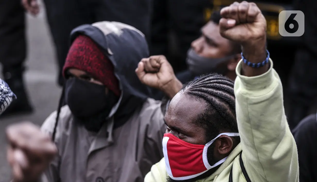 Masyarakat Papua mengenakan masker saat memperingati Operasi Trikora 19 Desember 1961 di Patung Kuda, Jakarta, Sabtu (19/12/2020). Dalam aksinya, massa menuntut 15 isu besar. (Liputan6.com/Johan Tallo)