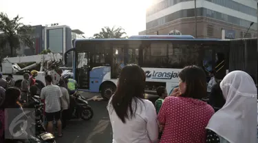 Sejumlah warga berdatangan ke lokasi bus TransJakarta yang terlibat kecelakaan dengan kereta api Senja Utama Solo di perlintasan kereta Mangga Dua, Jakarta, Kamis (19/5). Peristiwa tabrakan itu juga melibatkan mobil Avanza. (Liputan6.com/Faizal Fanani)