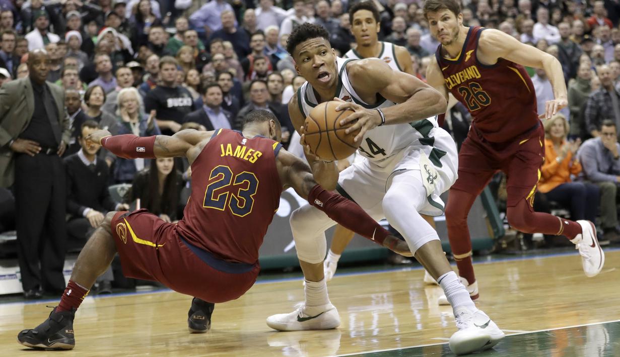 Pemain Milwaukee Bucks, Giannis Antetokounmpo mencuri bola dari kaki pemain Cleveland Cavaliers, LeBron James pada laga NBA basketball game di BMO Harris Bradley Center, Milwaukee, (19/12/2017). Bucks menang 119-116. (AP/Morry Gash)