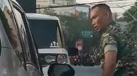 Tangkapan layar dari video yang menggambarkan seorang anggota TNI terlibat perselisihan sambil membawa pisau rambo di jalanan Kota Semarang, viral di media sosial. (Liputan6.com/ Ist)
