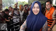 Pasangan suami-istri tersangka suap di Mahkamah Konstitusi Budi Antoni Aljufri (kanan) dan Suzanna keluar dari gedung KPK usai menjalani pemeriksaan, Jakarta, Rabu (22/7/2015). (Liputan6.com/Helmi Afandi)