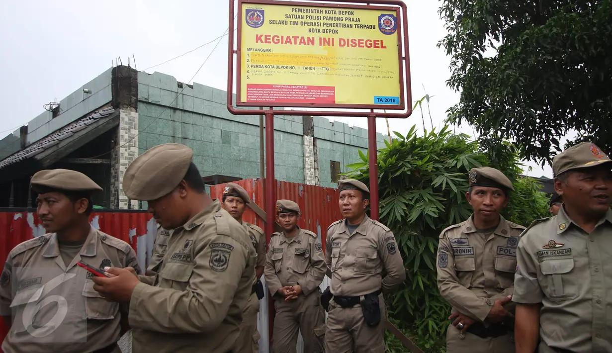 Petugas Satpol PP berjaga di depan tempat ibadah jemaah Ahmadiyah yang disegel di Jalan Raya Muchtar Sawangan, Depok, Jawa Barat, Jumat (24/2). (Liputan6.com/Immanuel Antonius)