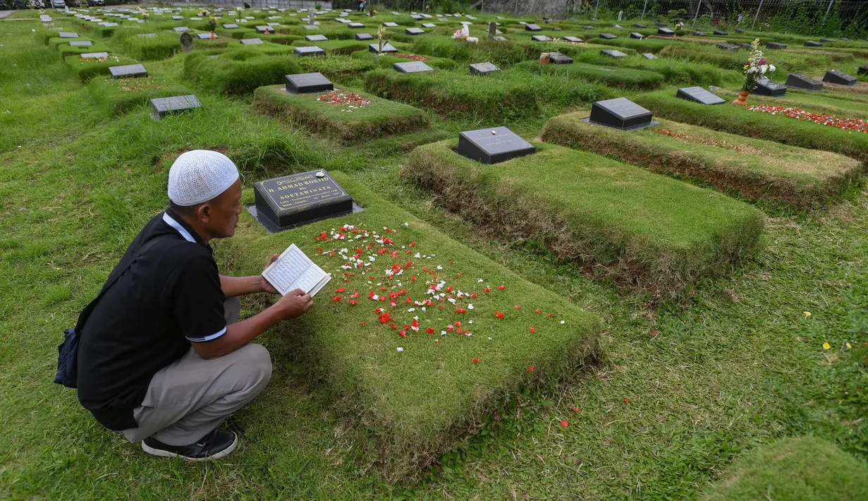 Warga saat berziarah saat Idul Fitri 1446 H di makam khusus Covid-19 TPU Srengseng Sawah, Jakarta, Selasa (1/4/2025). (merdeka.com/Arie Basuki)