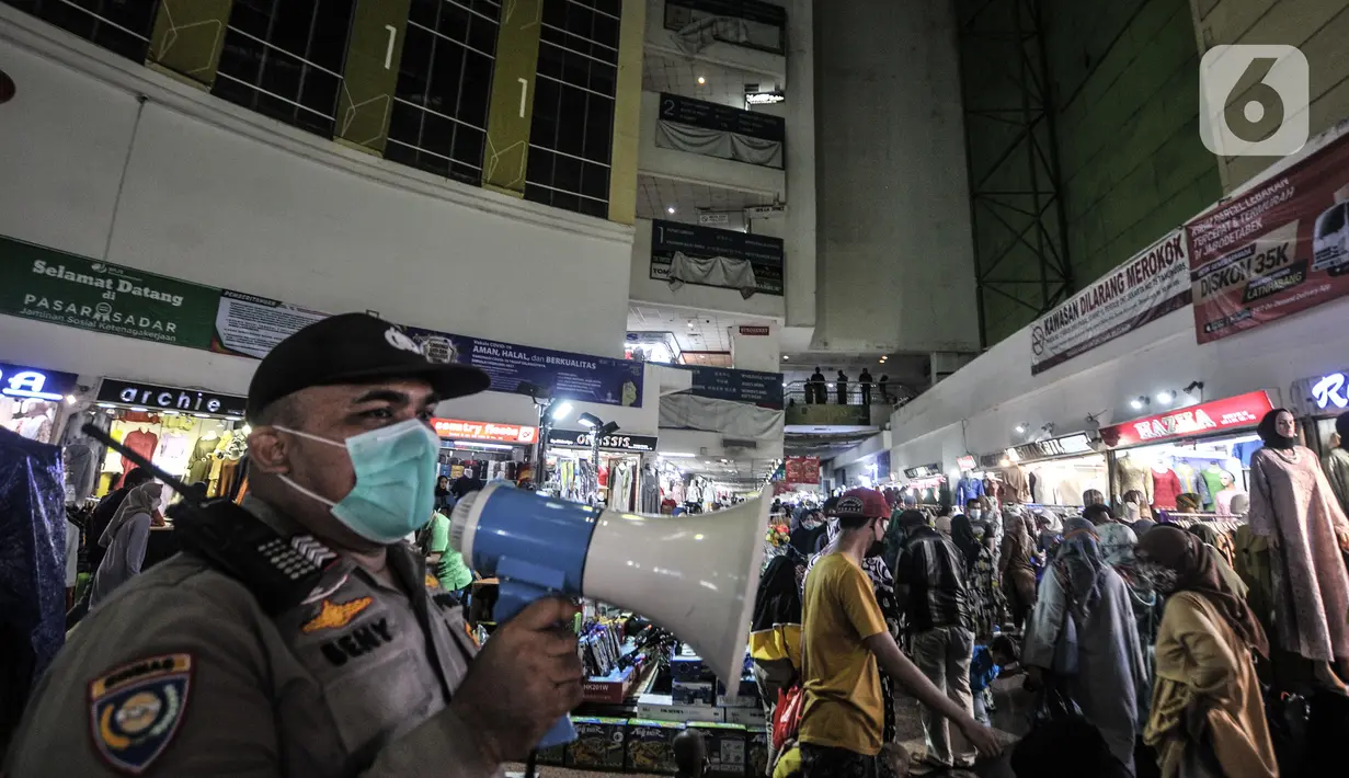 Polisi menggunakan pengeras suara untuk menghimbau protokol kesehatan kepada pengunjung Blok B Pasar Tanah Abang, Jakarta, Minggu (2/5/2021). Petugas gabungan memperketat penjagaan di pintu masuk Blok A dan B Pusat Grosir Tanah Abang guna mencegah kerumunan pengunjung. (merdeka.com/Iqbal S Nugroho)