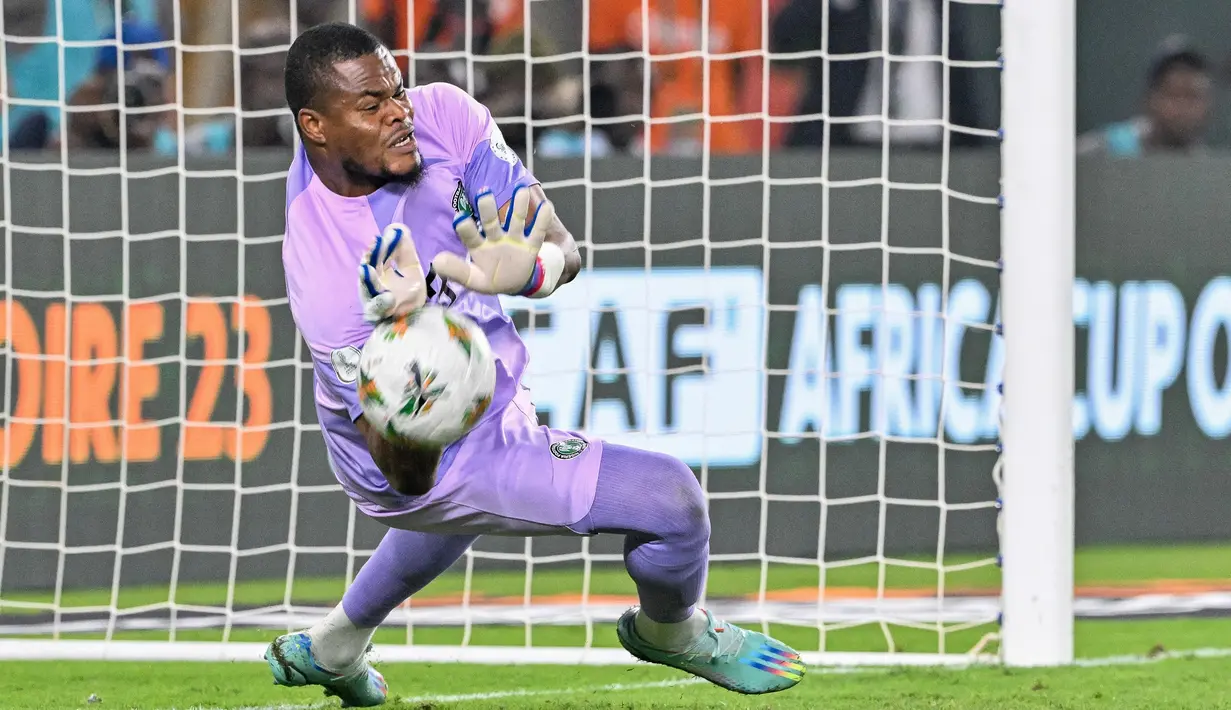 Kiper Nigeria, Stanley Nwabali, berhasil menghalau bola tendangan penalti pemain Afrika Selatan pada laga semifinal di Stade de la Paix, Kamis (8/2/2024). (AFP/Issouf Sanogo)