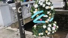 Sebuah karangan bunga berdiri dekat tiang lampu yang ditabrak mobil yang ditumpangi Ketua DPR Setya Novanto di Jalan Permata Berlian, Jakarta, Sabtu (18/11). Tiang lampu tersebut mendadak menjadi perhatian banyak masyarakat.  (Liputan6.com/Angga Yuniar)