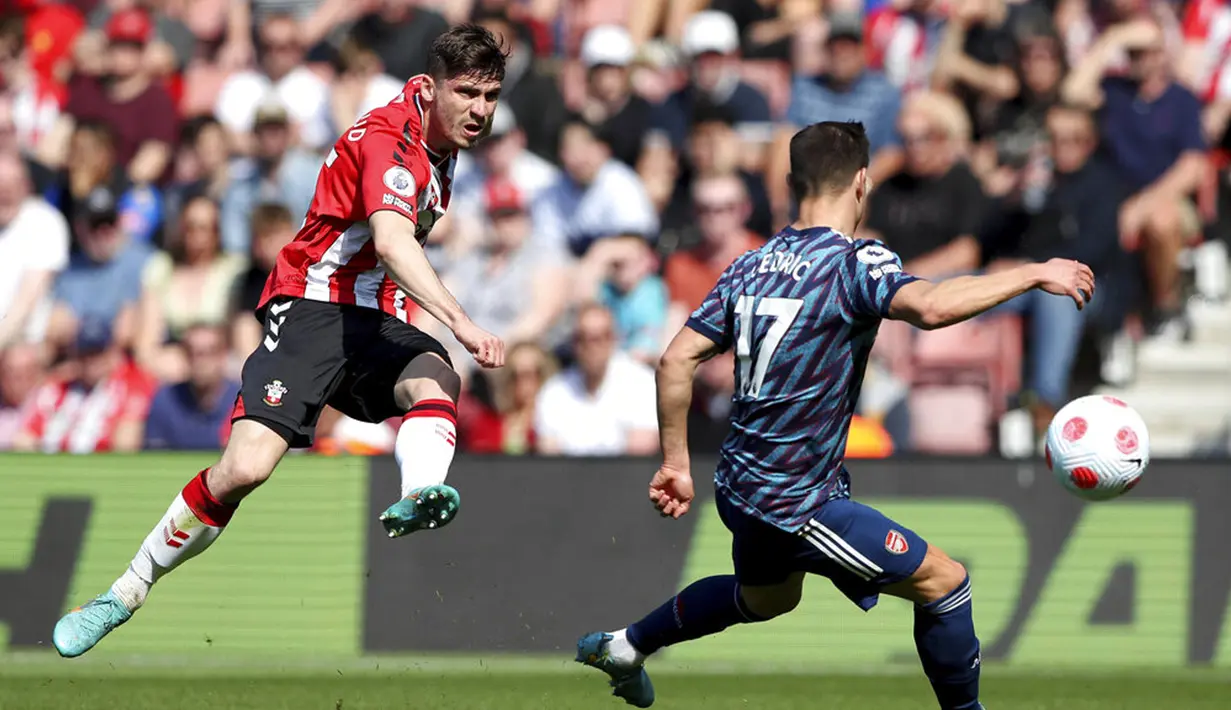 Pemain Southampton Romain Perraud (kiri) menendang bola melewati pemain Arsenal Cedric Soares pada pertandingan sepak bola Liga Inggris di St Mary's, Southampton, Inggris, 16 April 2022. Southampton menang 1-0. (Kieran Cleeves/PA via AP)