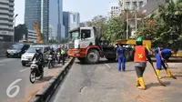 Petugas kepolisian mengatur lalu lintas akibat truk mengalami patah as di Jakarta, Selasa (29/9/2015). Imbas dari truk bermuatan alat berat mengalami patah as itu, Jalan Sudirman mengarah ke Jalan MH Thamrin terpantau padat. (Liputan6.com/Gempur M Surya)