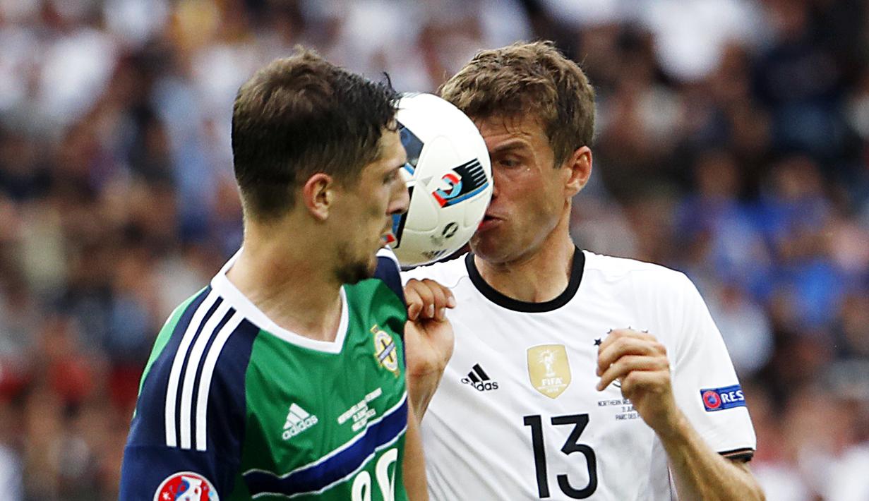 Pemain Jerman, Thomas Muller, berebut bola dengan pemain Irlandia Utara, Craig Cathcar, pada laga Grup C Piala Eropa 2016 di Parc des Princes, Paris, Selasa (21/6/2016). (AFP/Lionel Bonaventre)