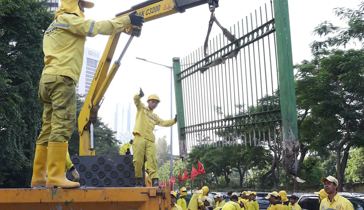Petugas Dinas Bina Marga membongkar pagar dan sepatator di Jalan Galunggung, Jakarta, Kamis (10/1). Pembongkaran dilakukan guna menghilangkan batas antar jalur sehingga diharapkan dapat mengurai simpul kemacetan. (Liputan6.com/Immanuel Antonius)