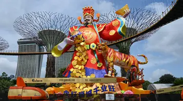 Pekerja memberikan sentuhan akhir pada patung lentera Dewa Keberuntungan untuk perayaan Tahun Baru Imlek mendatang di Gardens by the Bay Supertree Grove, Singapura, 18 Januari 2022. (Roslan RAHMAN/AFP)