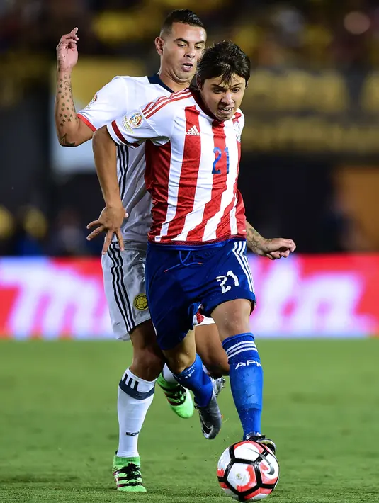 Gelandang Paraguay, Oscar Romero (Depan) membawa bola dari kejaran gelandang Kolombia, Edwin Cardona pada Copa America Centenario 2016 di Stadion Rose Bowl, AS (8/6). Kolombia menang atas Paraguay dengan skor 2-1. (AFP PHOTO/Frederic J. Brown)