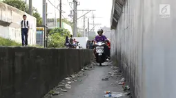 Suasana  jalan setapak di pinggir rel kereta di kawasan Tambora, Jakarta, Senin (10/7). Tidak tersedianya akses jalan untuk putar balik membuat warga terpaksa memanfaatkan jalan setapak tersebut. (Liputan6.com/Immanuel Antonius)