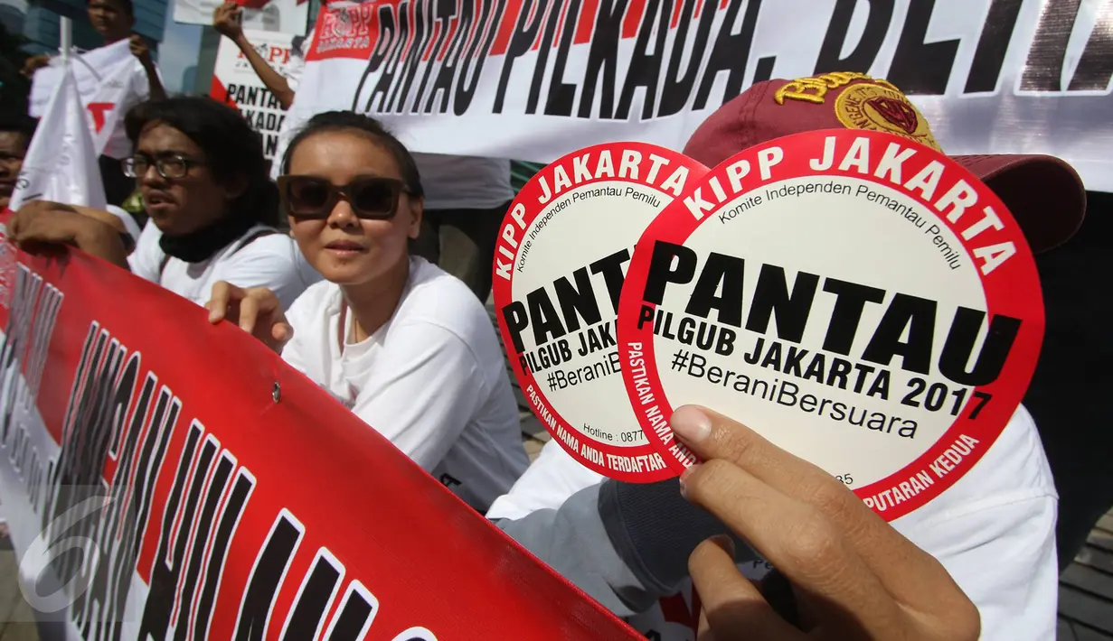 Peserta aksi menunjukan stiker yang berisi himbauan untuk pantau Pilgub Jakarta 2017, Minggu (12/3). Dalam aksi tersebut juga mendesak KPU dan Bawaslu lebih profesional dalam menjalankan tugasnya. (Liputan6.com/Immanuel Antonius)