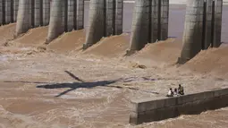 Seorang Angkatan Udara India bersiap  menyelamatkan dua di antara empat nelayan yang terperangkap dalam banjir di Sungai Tawi di Jammu, India (19/8/2019). Permukaan air di banyak sungai di India utara meningkat setelah hujan lebat di musim hujan. (AP Photo/Channi Anand)