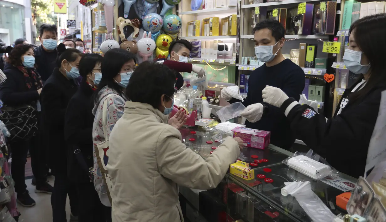 Warga menerima masker wajah gratis dalam sebuah toko kosmetik di Tsuen Wan, Hong Kong, Selasa (28/1/2020). Hong Kong terkonfirmasi memiliki delapan kasus infeksi virus corona. (AP Photo/Achmad Ibrahim)