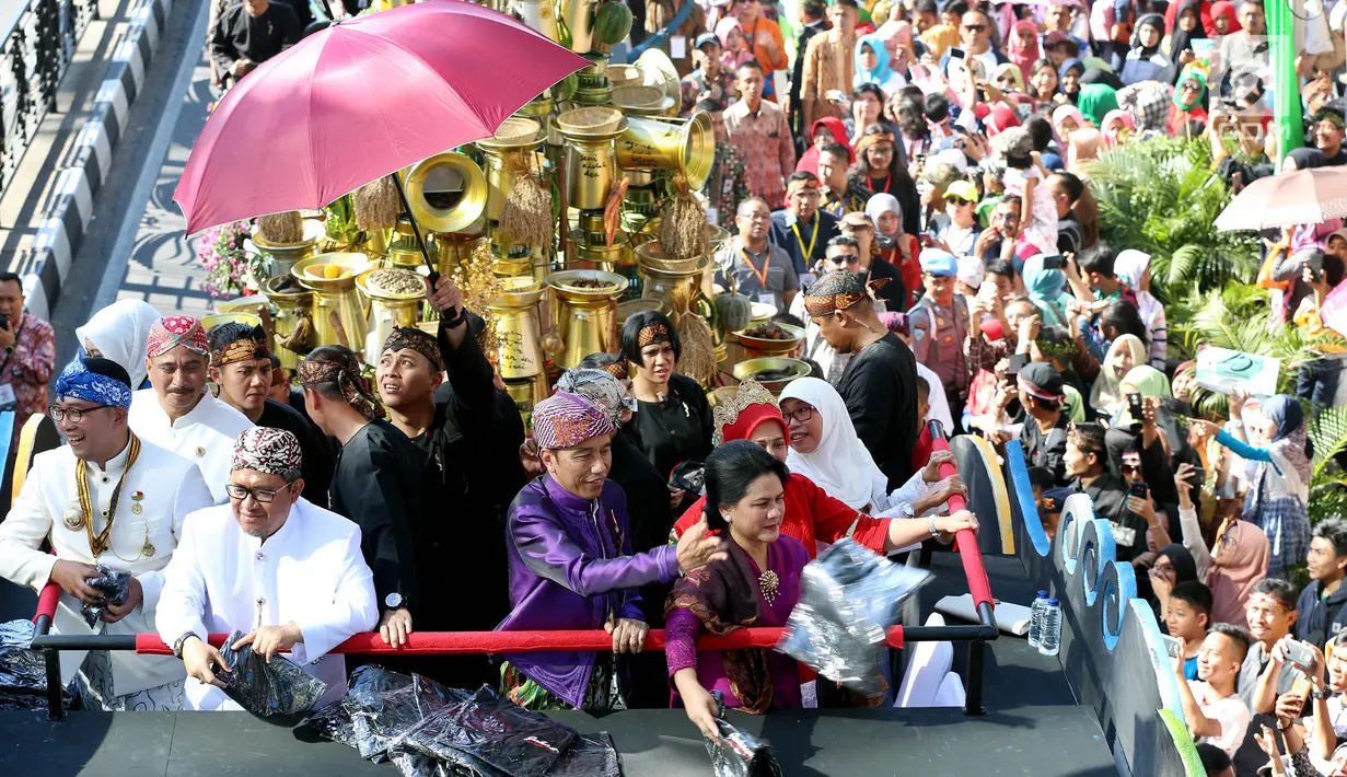 Presiden Joko Widodo (Jokowi) bersama Ibu Negara, Iriana Joko Widodo membagikan kaus dari atas kendaraan hias berbentuk kepala burung garuda pada Karnaval Kemerdekaan Pesona Parahyangan 2017 di Bandung, Sabtu (26/8). (Liputan6.com/Johan Tallo)