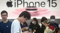 Seorang pria mencoba ponsel iPhone 15 yang baru saja diluncurkan di sebuah toko Apple di Hangzhou, di provinsi Zhejiang, China pada 22 September 2023. (AFP/China OUT)