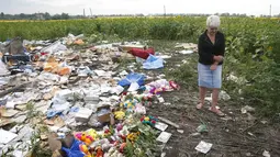 Warga Ukraina yang bersimpati datang ke tempat jatuhnya pesawat lalu meletakkan bunga dan boneka , Ukraina, Sabtu (19/07/2014) (REUTERS/Maxim Zmeyev)