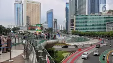 Sejumlah kendaraan bermotor melintas di kawasan Bundaran Hotel Indonesia, ruas Jalan MH Thamrin, Jakarta, Minggu (13/4/2025). (Liputan6.com/Angga Yuniar)