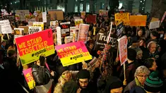 Sejumlah orang turun ke jalan, bergabung dalam aksi unjuk rasa di luar Downing Street, London, Senin (30/1). Mereka memprotes kebijakan Presiden AS Donald Trump yang melarang Muslim dari sejumlah negara memasuki Amerika Serikat. (AP Photo/Alastair Grant)