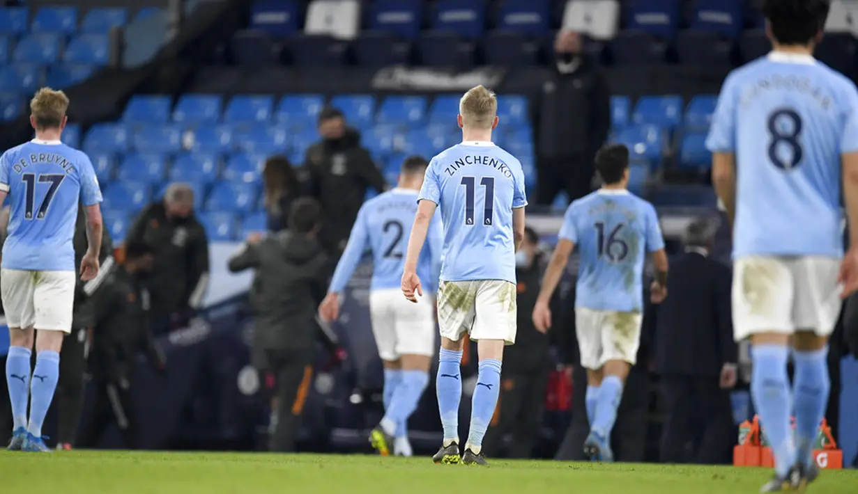 Pemain Manchester City meninggalkan lapangan pada akhir pertandingan melawan Manchester United pada pertandingan Liga Inggris di Etihad Stadium, Manchester, Inggris, Minggu (7/3/2021). Manchester United mempermalukan Manchester City dengan skor 2-0. (Peter Powell/Pool via AP)