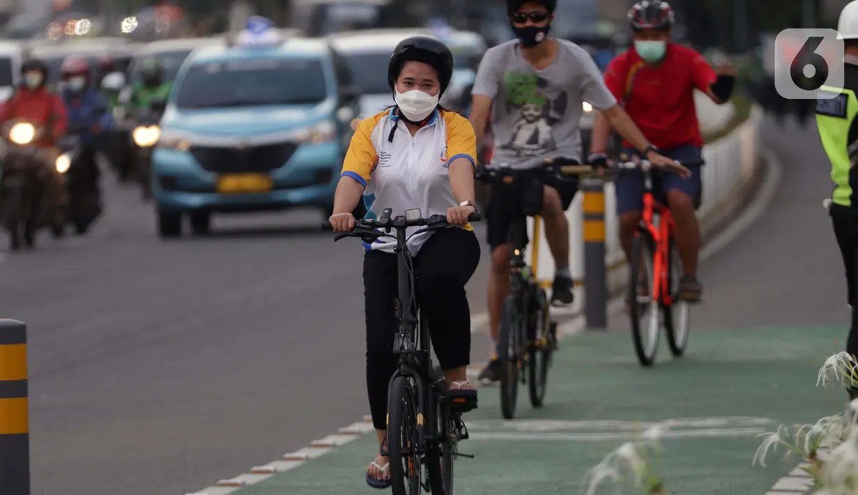 Warga mengenakan masker bersepeda di jalan Jenderal Sudirman, Jakarta, Jumat (25/6/2021). Hari ini Jumat (25/6), Provinsi DKI Jakarta mencatat penambahan kasus konfirmasi positif Covid-19 sebanyak 6.934 orang. (Liputan6.com/Helmi Fithriansyah)